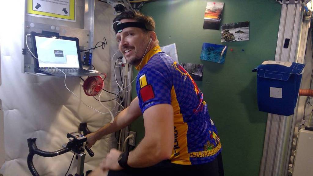 HERA crew member Christopher Roberts rides an indoor bicycle inside a tiny habitat that NASA uses to help simulate missions to Mars.