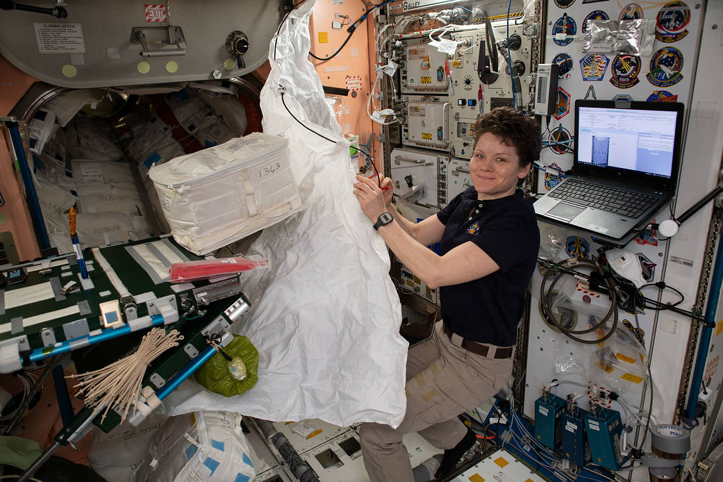 NASA astronaut Anne McClain assembles a hygiene cover