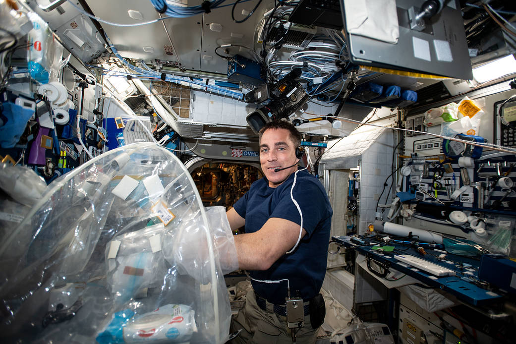 NASA astronaut Chris Cassidy services biological samples in a glovebag