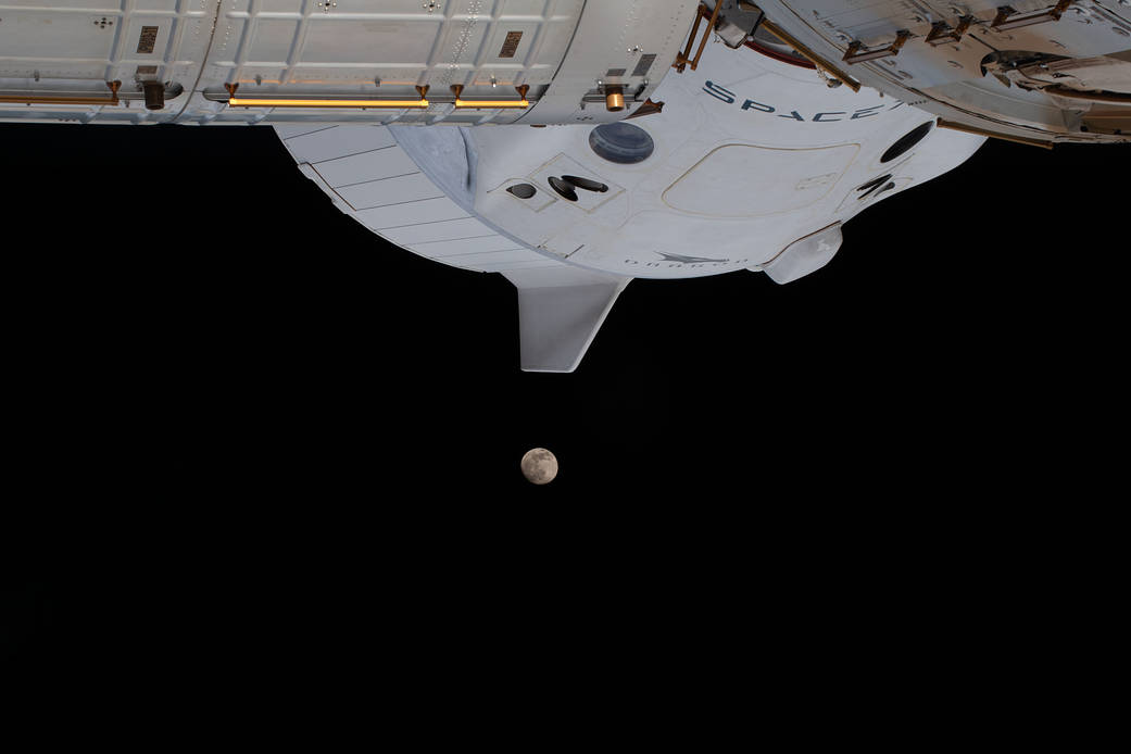 The waxing gibbous moon below the SpaceX Crew Dragon