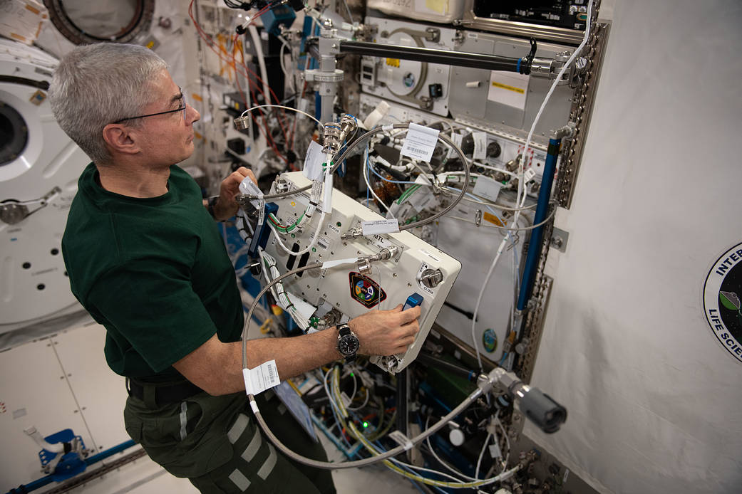 Astronaut Mark Vande Hei relocates a space biology research platform