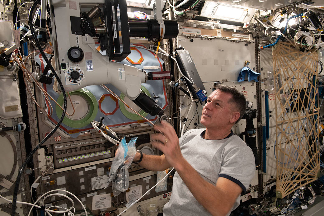 Astronaut Shane Kimbrough sets up a microscope