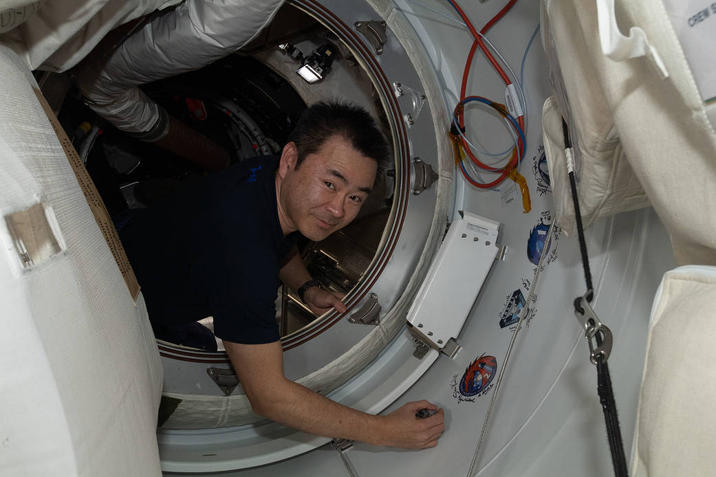 Astronaut Akihiko Hoshide signs the station vestibule