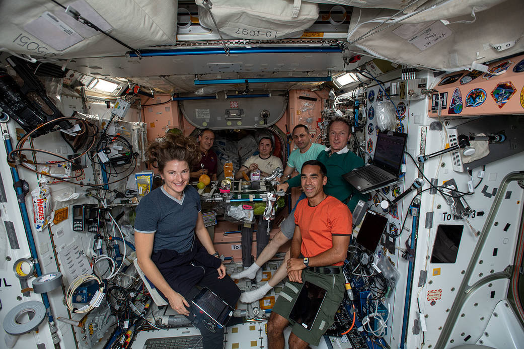 Expedition 66 crew members gather for a Thanksgiving meal