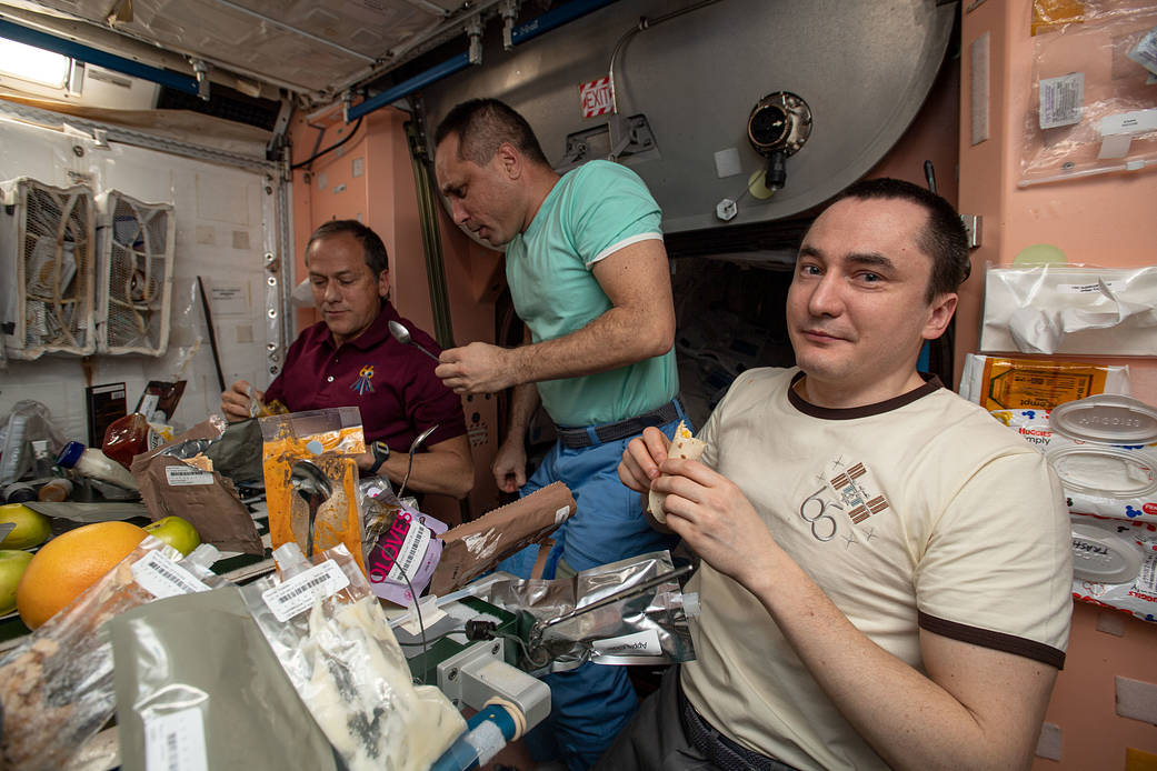 Expedition 66 crew members gather for a Thanksgiving meal