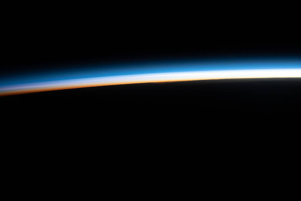 The last rays of an orbital sunset illuminate Earth's horizon