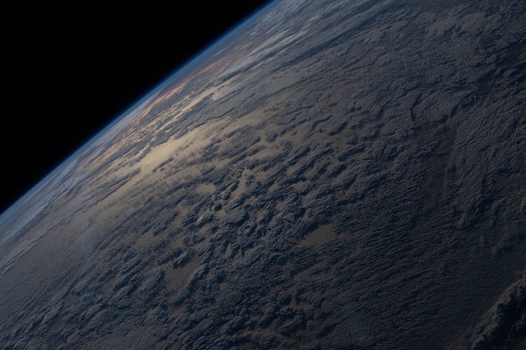 The sun's glint beams off a partly cloudy, southern Atlantic Ocean