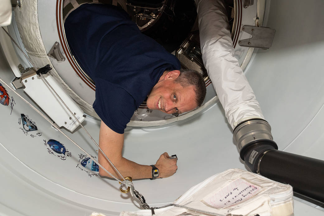Astronaut Bob Hines signs his name around the Crew-4 sticker