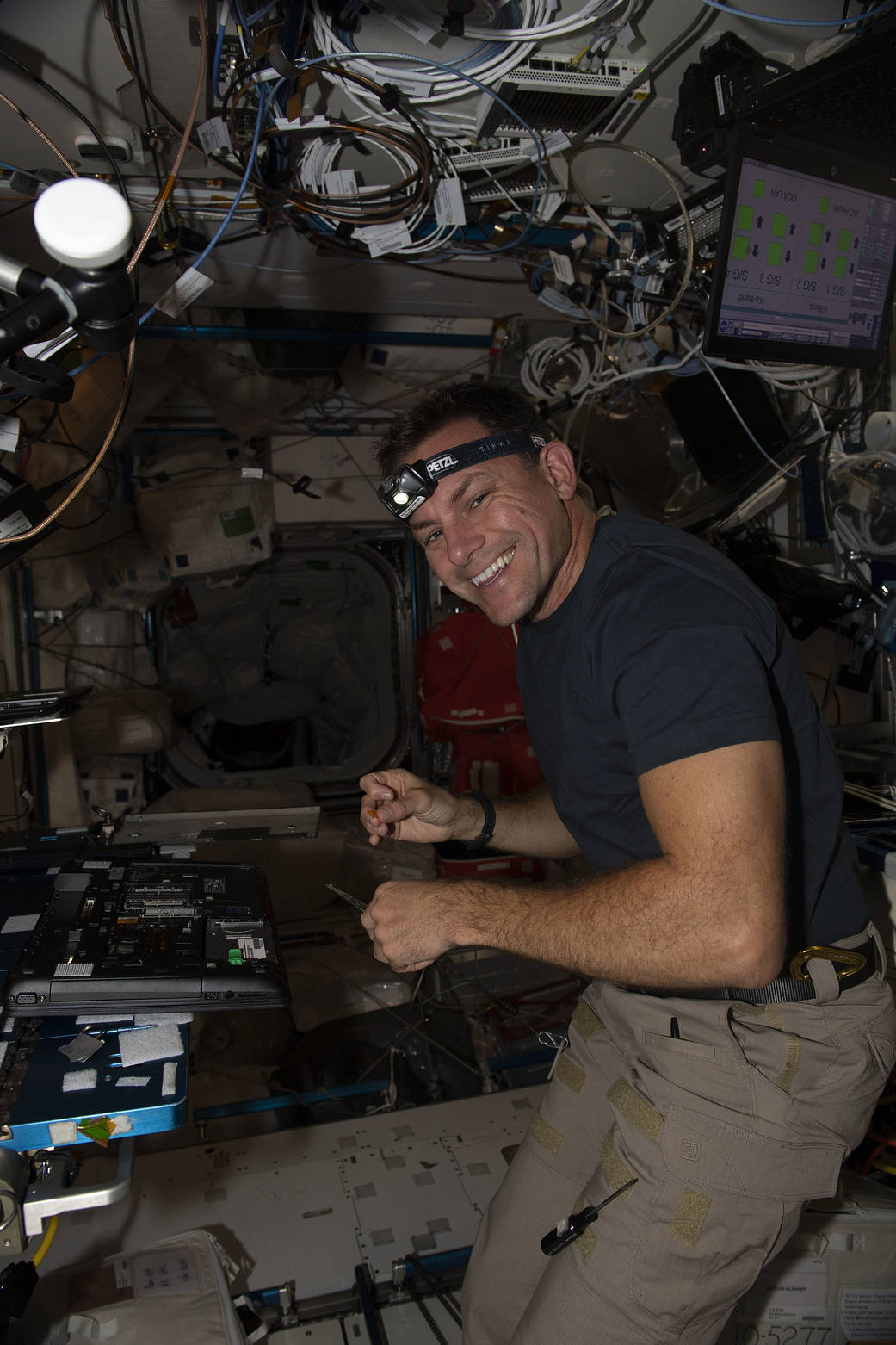 Astronaut Josh Cassada performs laptop computer maintenance