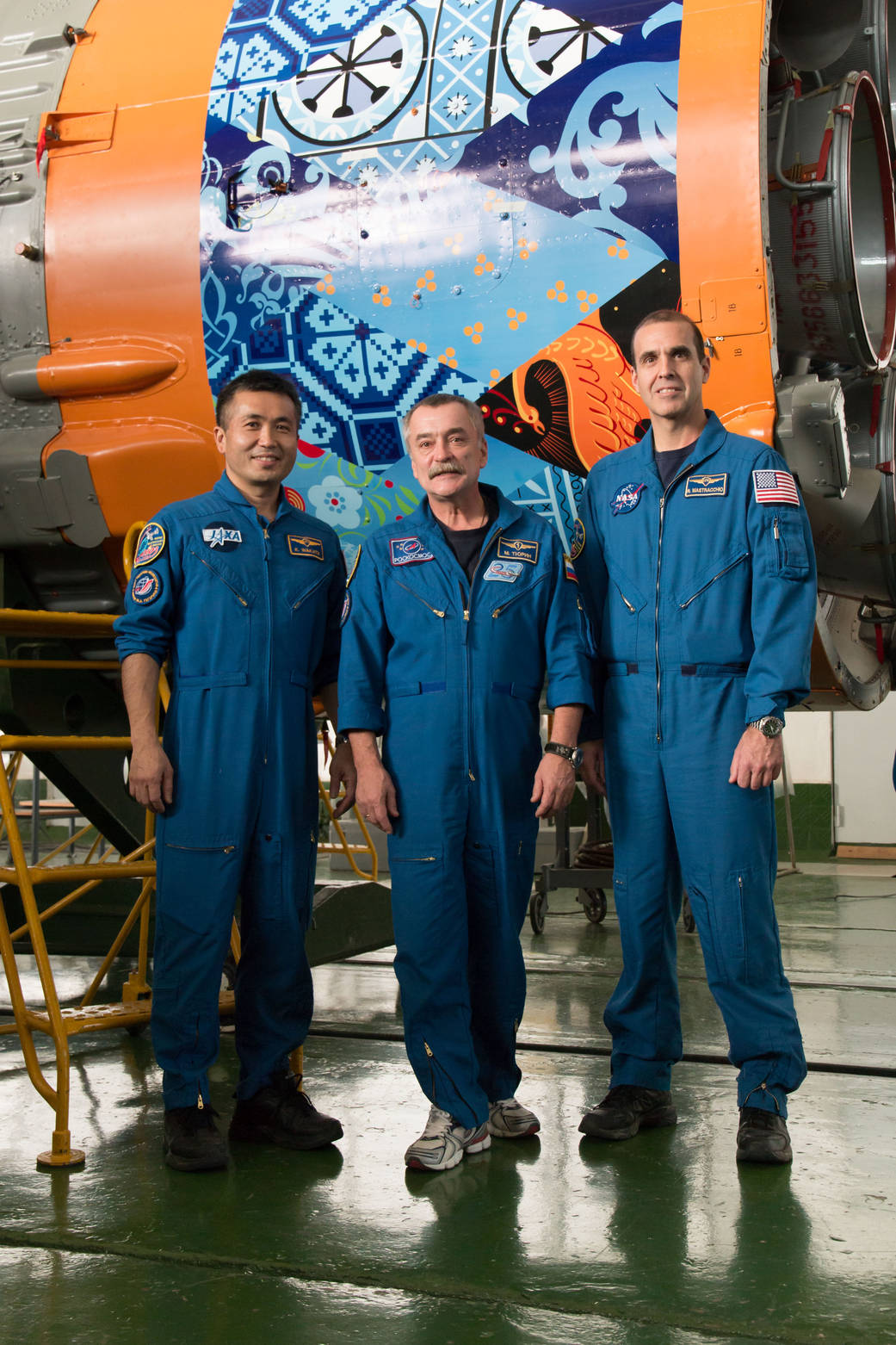 Koichi Wakata, Mikhail Tyurin and Rick Mastracchio in front of the first stage of the Soyuz rocket