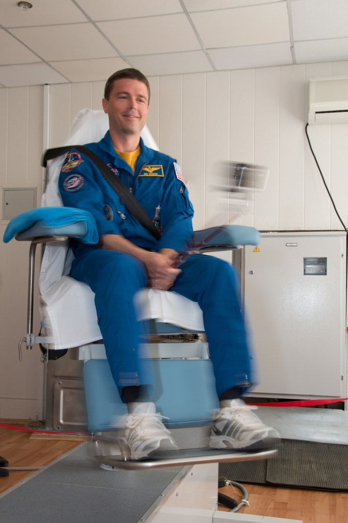 Engineer Reid Wiseman of NASA takes a ride in a spinning chair