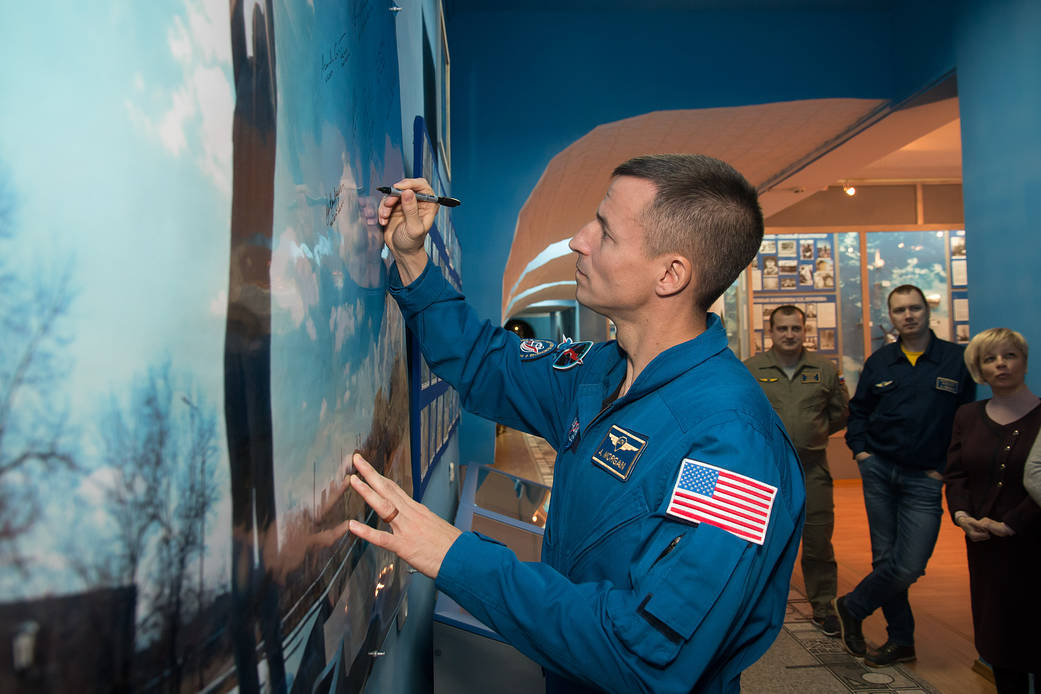 Expedition 58 backup crew member Drew Morgan of NASA signs a wall mural
