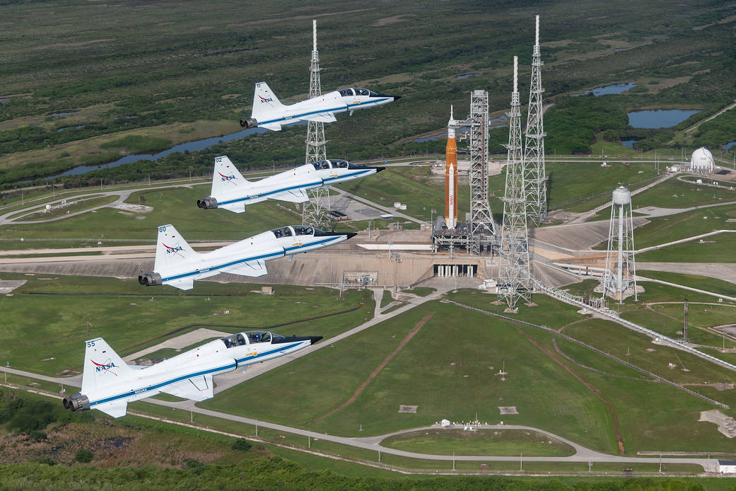 NASA T-38s fly in formation above the Space Launch System rocket on Launch Pad 39B.