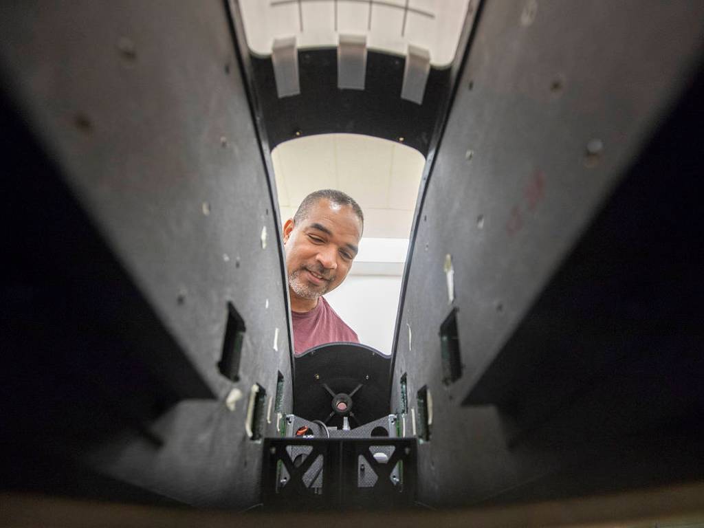 Langley engineering technician Sam James looks inside a full-scale model of Langley Aerodrome No. 8.