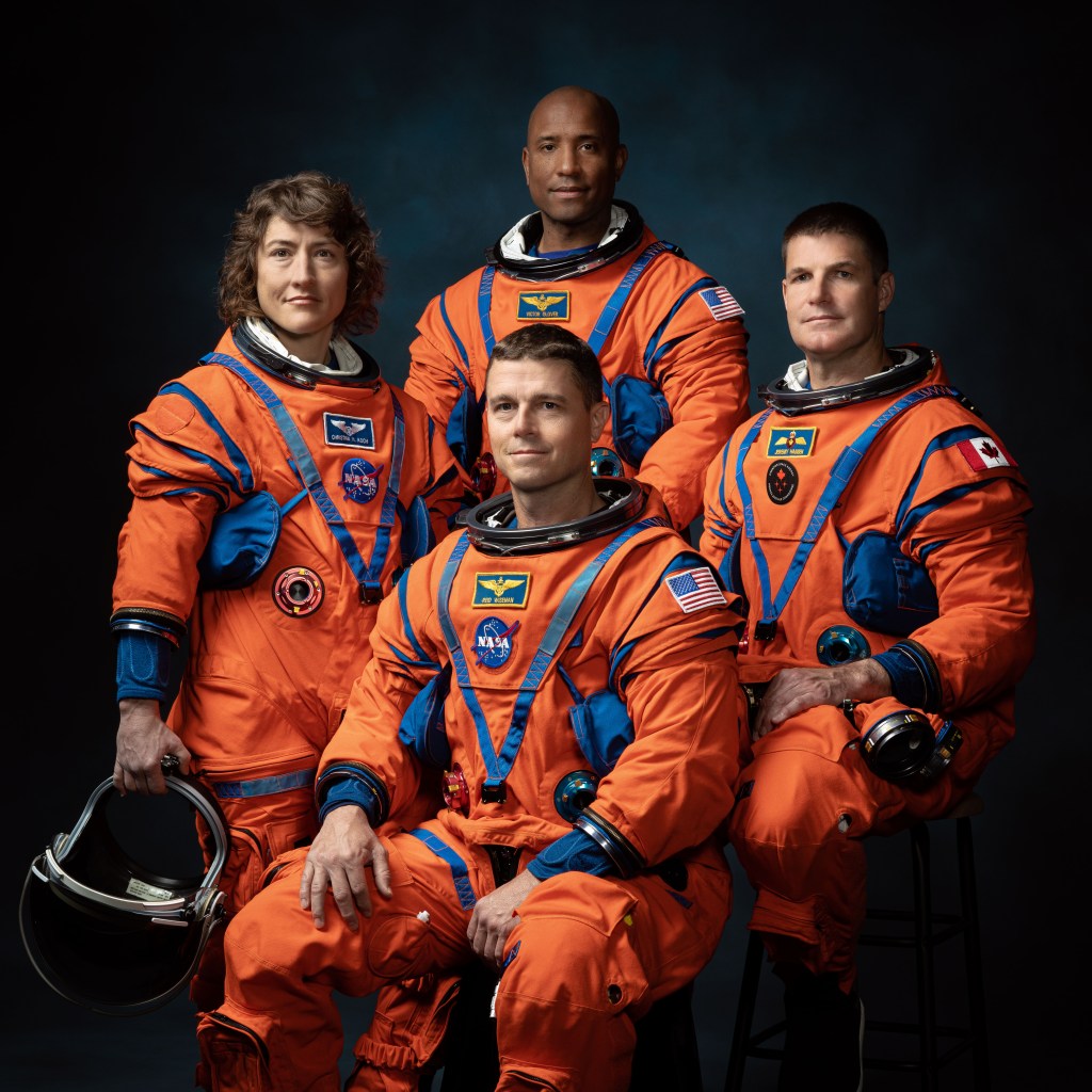 美国宇航局阿耳特弥斯II号任务的机组人员身穿橙色飞行服（从左至右）：美国宇航局宇航员克里斯蒂娜·哈莫克·科赫（Christina Hammock Koch）、里德·怀斯曼（Reid Wiseman）（坐下）、维克托·格洛弗（Victor Glover）和加拿大航天局宇航员杰里米·汉森（Jeremy Hansen）。
