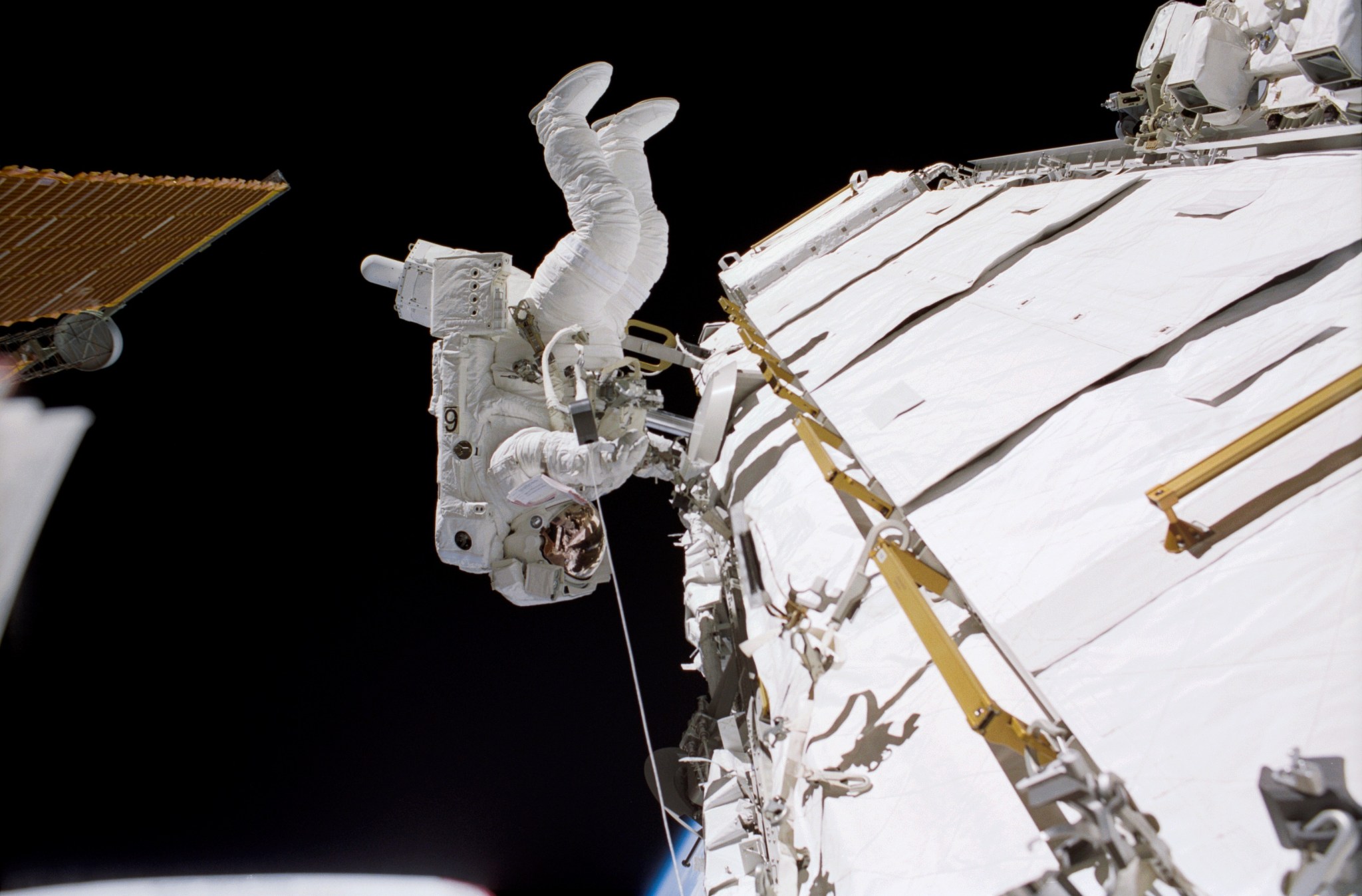 Astronaut John B. Herrington, STS-113 mission specialist, traverses along a truss on the International Space Station during the mission's third spacewalk.