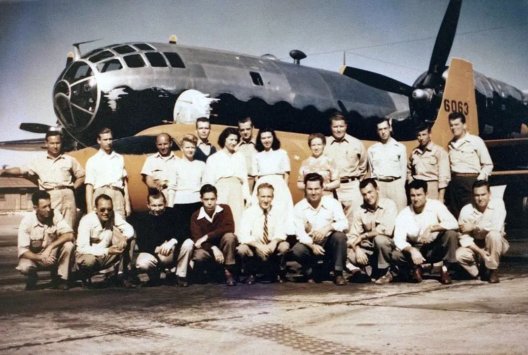 Group posing in front of bomber.