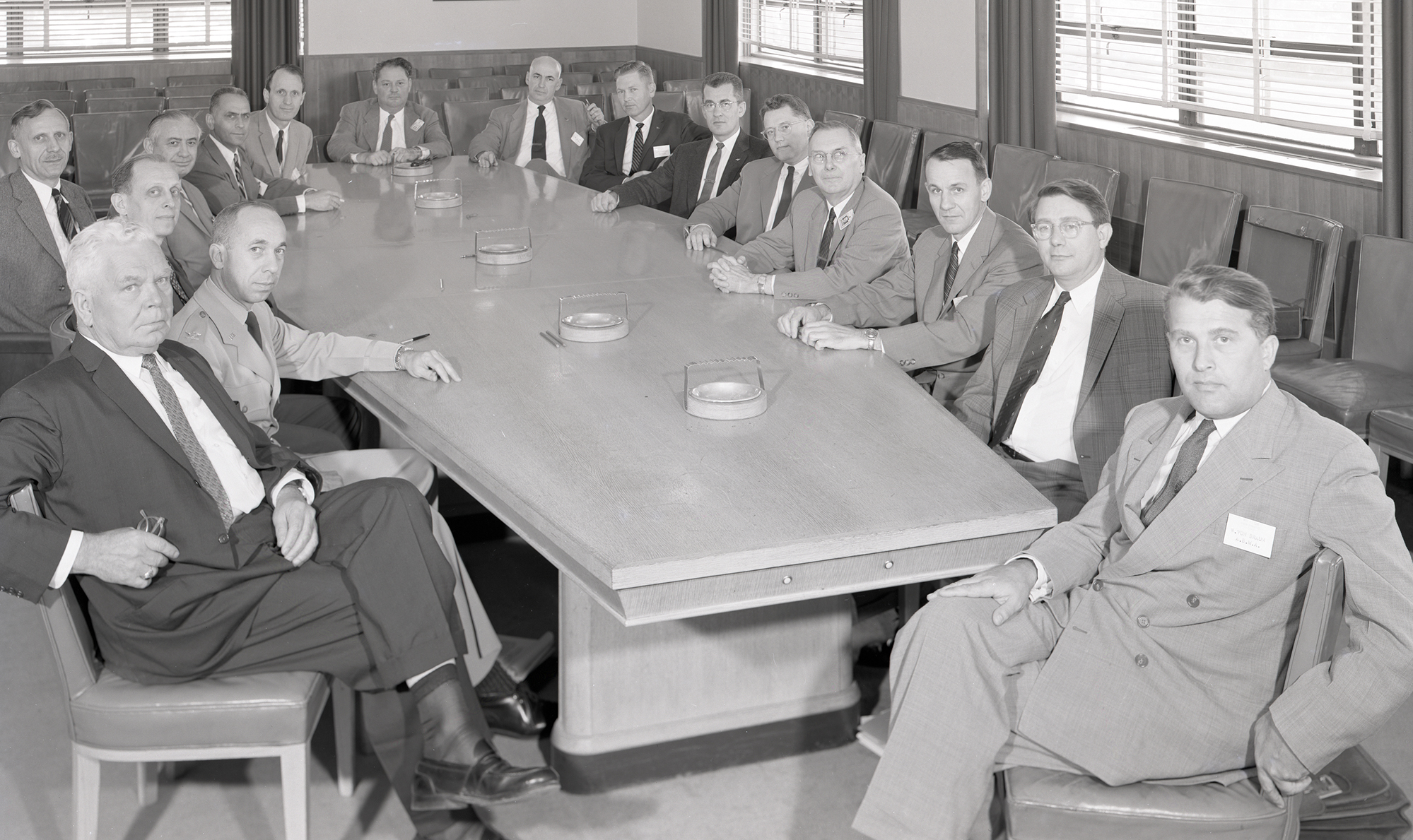 Group of men seated around table.