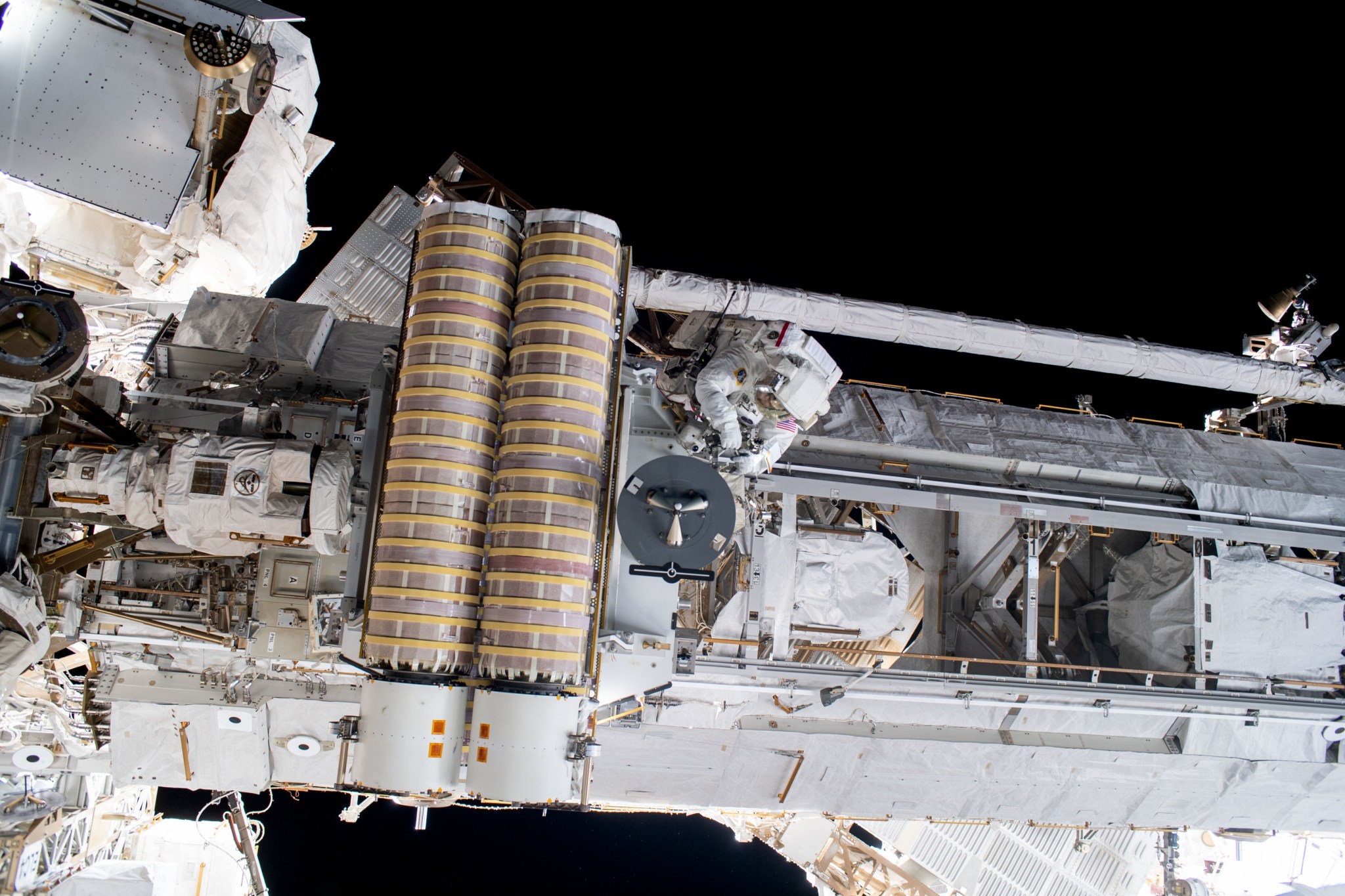 iss069e018600 (June 9, 2023) --- NASA astronaut and Expedition 69 Flight Engineer Stephen Bowen (center) is pictured working to release a stowed roll-out solar array attached to the International Space Station's starboard truss structure during a six-hour and three-minute spacewalk.