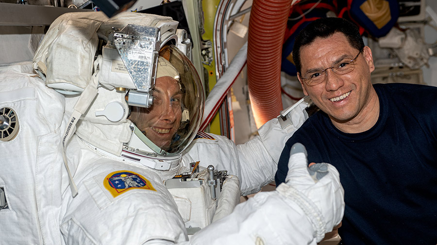 Astronaut Frank Rubio (right) assists astronaut Woody Hoburg during a fit check of his spacesuit inside the space station's Quest airlock.