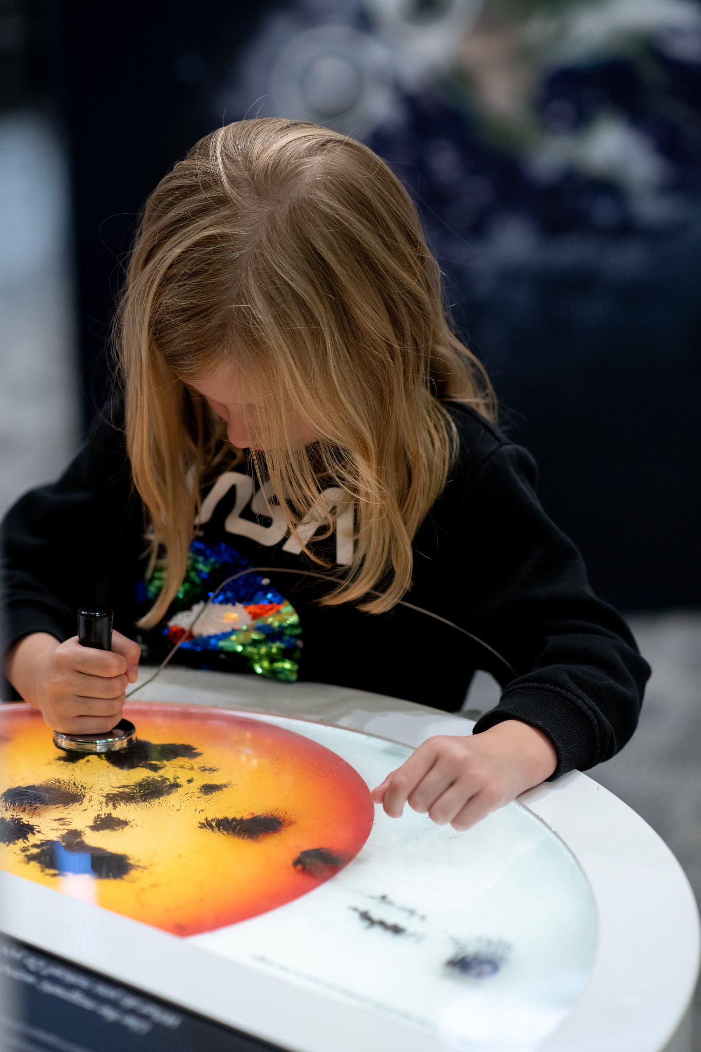 A young child interacts with a sunspot exhibit.