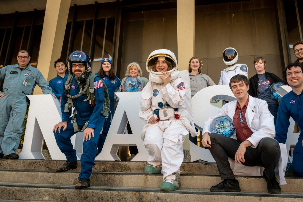 Marshall Space Flight Center's Director, Jody Singer, poses along with other members of the community in front of large white block letters that spell out NASA for Artemis on the Square in Huntsville, Alabama.