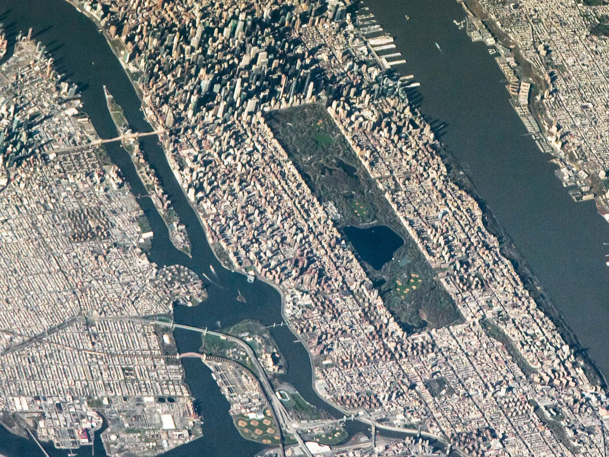 Photo of part of Manhattan, including all of Central Park, taken from the International Space Station one morning in April 2022. The photo is looking from north to south and the shadows of Midtown skyscrapers stretch westward.
