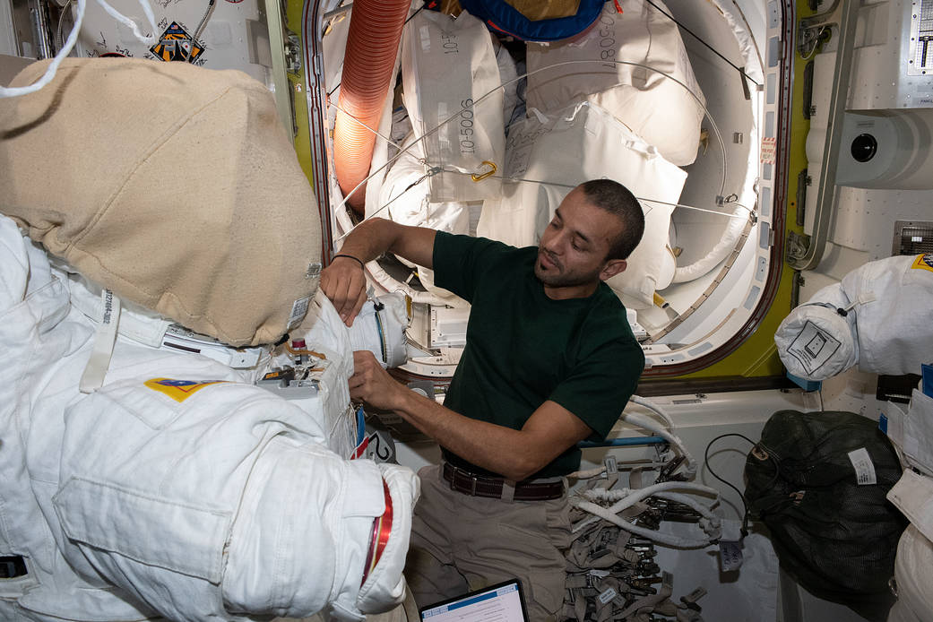 UAE astronaut Sultan Alneyadi prepares a spacesuit for a spacewalk