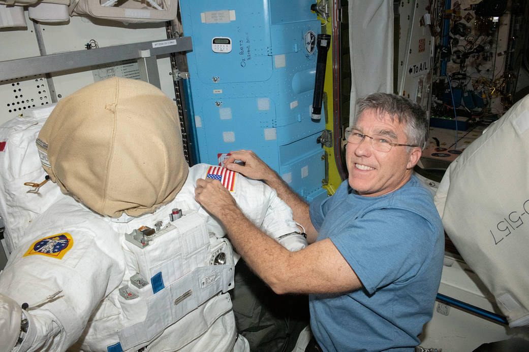 NASA astronaut Stephen Bowen prepares a spacesuit for a spacewalk