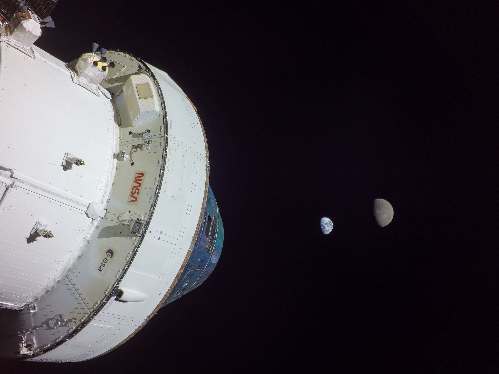A spacecraft with the Moon and Mars in the distance