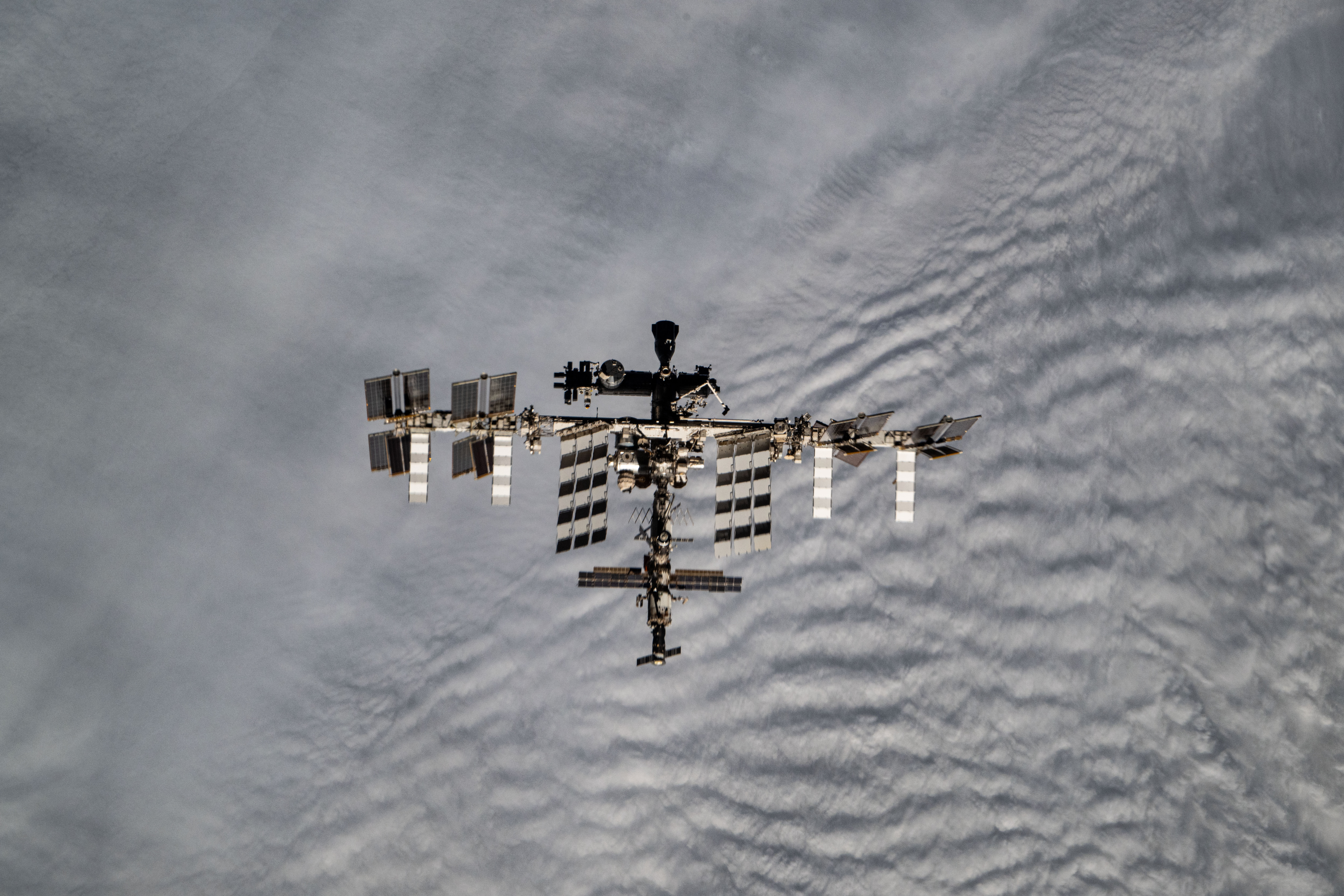 The International Space Station is pictured from the SpaceX Dragon crew spacecraft by a SpaceX Crew-8 member shortly after undocking from the Harmony module's space-facing port. The orbital outpost was soaring 272 miles above the cloudy Patagonia region of South America at the time of this photograph.