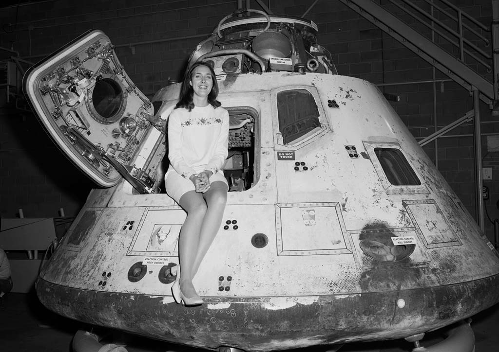 Woman sitting on Apollo capsule.
