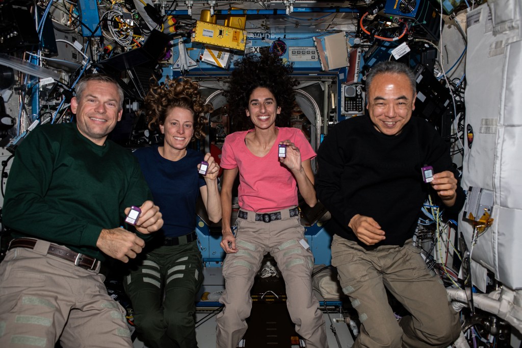 (From left) Expedition 70 Commander Andreas Mogensen of ESA (European Space Agency); and Flight Engineers Loral O'Hara and Jasmin Moghbeli, both from NASA; and Satoshi Furukawa of JAXA (Japan Aerospace Exploration Agency), pose for a portrait aboard the International Space Station's Destiny laboratory module. The quartet is showing off crew active dosimeters that monitor the amount of radiation astronauts are exposed to in the microgravity environment.