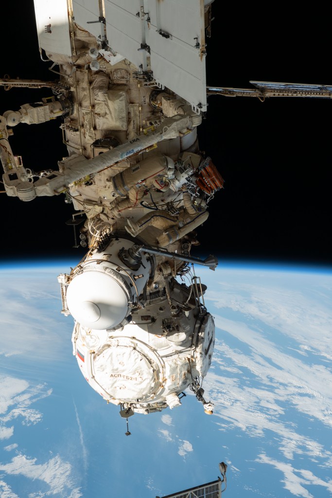 Expedition 70 Flight Engineers Oleg Kononenko (suit with red stripes) and Nikolai Chub (suit with blue stripes), both from Roscosmos, are pictured during a spacewalk to inspect a backup radiator, deploy a nanosatellite, and install communications hardware on the International Space Station's Nauka science module.