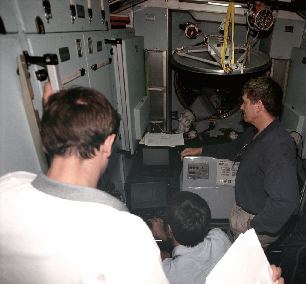The three crew members for ISS Expedition 1 train with computers on the trainer/mockup for the Zvezda Service Module. From the left are cosmonauts Yuri Gidzenko, Soyuz commander; and Sergei Krikalev, flight engineer; and astronaut William Shepherd, mission commander. The session took place at the Gagarin Cosmonaut Training Center in Russia.