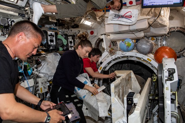 Expedition 67 Flight Engineers Kjell Lindgren and Kayla Barron, both from NASA, and Samantha Cristoforetti from ESA (European Space Agency) are pictured checking out systems inside the International Space Station's Kibo laboratory module. Partially visible at the top of this image, is NASA astronaut Jessica Watkins also participating in the station familiarization activities.