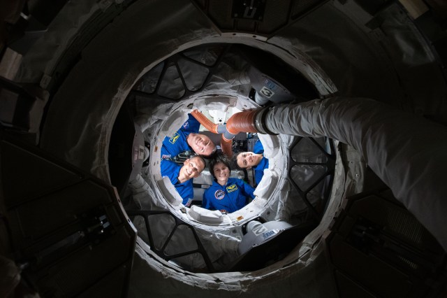 Expedition 67 Flight Engineers (clockwise from bottom) Samantha Cristoforetti, Bob Hines, Kjell Lindgren, and Jessica Watkins, smile for a portrait from inside the Boeing CST-100 Starliner crew ship. The quartet is looking through the Harmony module's forward international docking adapter, to which Starliner is docked, and into the International Space Station.