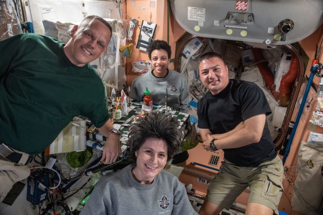 (Clockwise from left) Expedition 67 Flight Engineers Bob Hines, Jessica Watkins, and Kjell Lindgren, all from NASA, and Samantha Cristofroetti from ESA (European Space Agency), pose for a portrait during dinner time in the Unity module of the International Space Station.