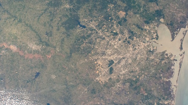 Houston, Texas (home of NASA's Johnson Space Center) and its surrounding suburbs are pictured from the International Space Station as it orbited 261 miles above the Lone Star State. Also prominent in this photograph, are Galveston Bay and Galveston Island on the Gulf of Mexico.