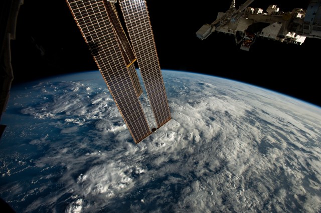 A set of the International Space Station's main solar arrays and the Kibo laboratory module's external pallet (top right) are pictured as the orbiting lab soared 260 miles above a cloudy Atlantic Ocean off the coast of northern Brazil.
