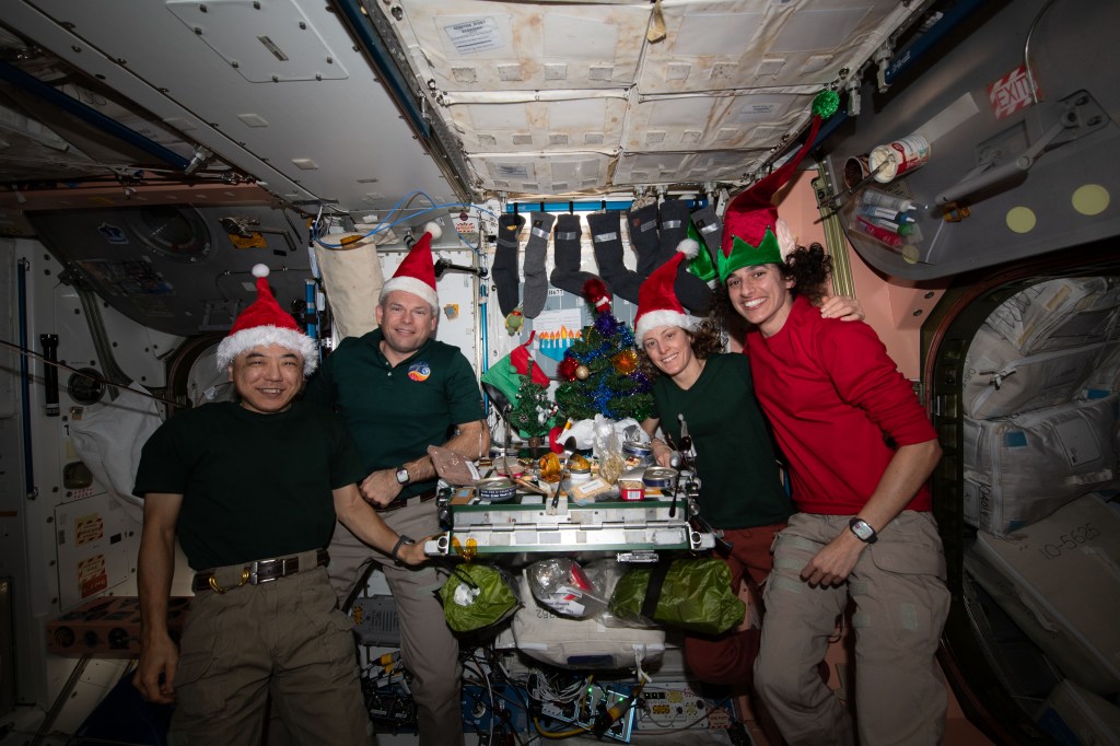 Four Expedition 70 crewmates join each other inside the International Space Station's Unity module for a Christmas Day meal. From left are, Flight Engineer Koichi Wakata from JAXA (Japan Aerospace Exploration Agency); Commander Andreas Mogensen from ESA (European Space Agency); and NASA Flight Engineers Loral O'Hara and Jasmin Moghbeli.