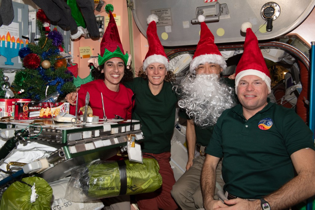 Four Expedition 70 crewmates join each other inside the International Space Station's Unity module for Christmas Eve festivities. From left are, NASA Flight Engineers Jasmin Moghbeli and Loral O'Hara; Flight Engineer Koichi Wakata from JAXA (Japan Aerospace Exploration Agency); and Commander Andreas Mogensen from ESA (European Space Agency).