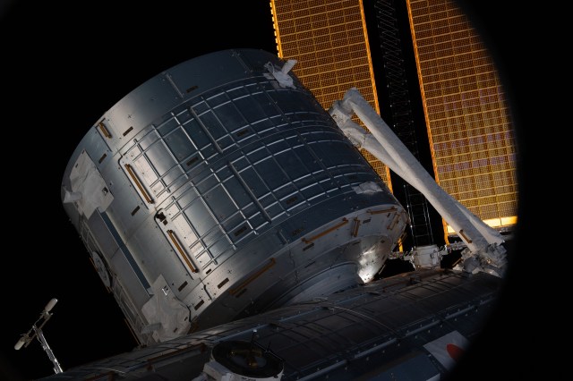 This view from a window on Boeing's CST-100 Starliner crew ship shows the Kibo laboratory module's logistics module from the Japan Aerospace Exploration Agency (JAXA) on the International Space Station. A portion of the Japanese robotic arm and the orbiting lab's main solar arrays are also visible.