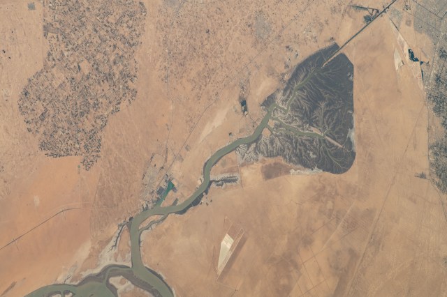 The Khawr az-Zubayr Waterway (at bottom) separates the Middle Eastern nations of Kuwait and Iraq on the Persian Gulf coast. At top left, is the desert town of Abdali, Kuwait. At right, is the fertile, agricultural town of Abu Al-Khaseeb, Iraq. The International Space Station was orbiting 262 miles above Saudi Arabia near the island nation of Bahrain at the time this photograph was taken.