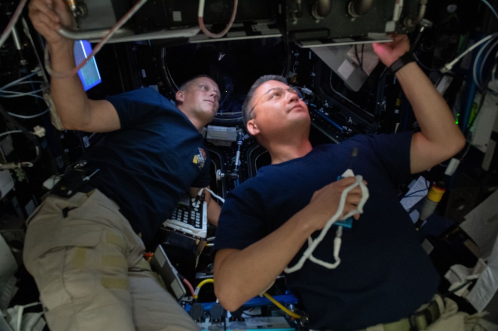 NASA astronauts (from left) Bob Hines and Kjell Lindgren are pictured inside the International Space Station's seven-windowed cupola monitoring the approach and rendezvous of Boeing's CST-100 Starliner spacecraft on the company's Orbital Flight Test-2 mission.