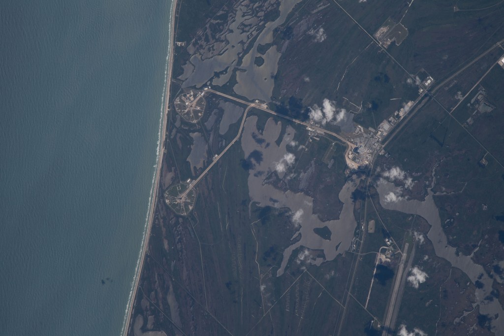 The International Space Station was orbiting just off the coast of Cape Canaveral, Florida, about 260 miles above the Atlantic Ocean when Expedition 67 Flight Engineer Raja Chari photographed NASA's Kennedy Space Center. The agency's two launch pads, 39A (at top) and 39B (at bottom), are clearly seen on the beach. Standing at launch pad 39B is NASA's Space Launch System (SLS) rocket with the Orion spacecraft atop. The rocket is being prepared for the uncrewed Artemis I mission "that will demonstrate NASA’s commitment and capacity to extend humanity’s presence on the Moon – and beyond."