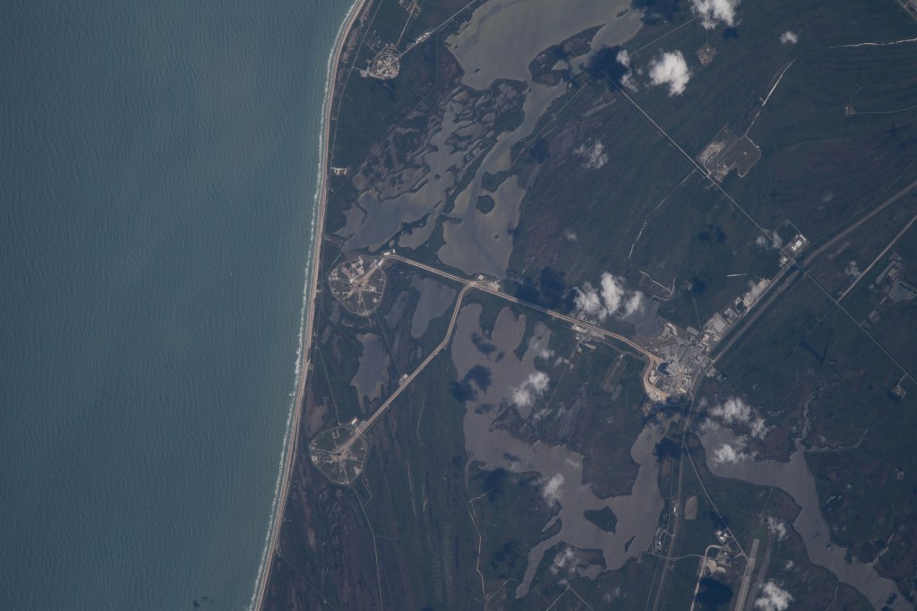 The International Space Station was orbiting just off the coast of Cape Canaveral, Florida, about 260 miles above the Atlantic Ocean when Expedition 67 Flight Engineer Raja Chari photographed NASA's Kennedy Space Center. The agency's two launch pads, 39A (at top) and 39B (at bottom), are clearly seen on the beach. Standing at launch pad 39B is NASA's Space Launch System (SLS) rocket with the Orion spacecraft atop. The rocket is being prepared for the uncrewed Artemis I mission "that will demonstrate NASA’s commitment and capacity to extend humanity’s presence on the Moon – and beyond."