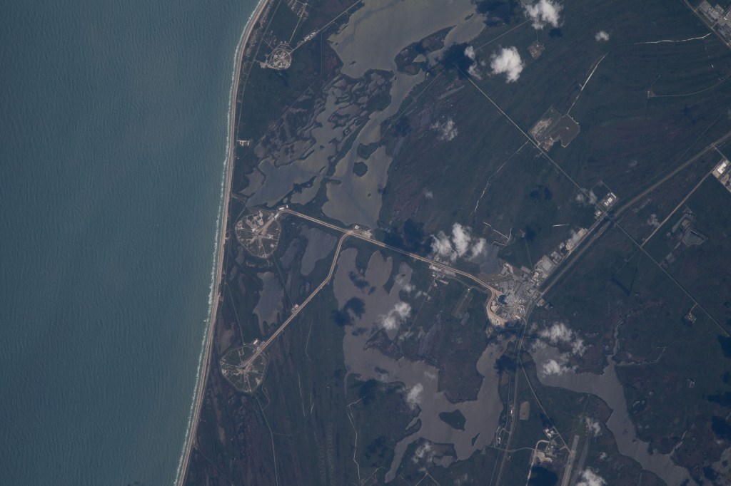 The International Space Station was orbiting just off the coast of Cape Canaveral, Florida, about 260 miles above the Atlantic Ocean when Expedition 67 Flight Engineer Raja Chari photographed NASA's Kennedy Space Center. The agency's two launch pads, 39A (at top) and 39B (at bottom), are clearly seen on the beach. Standing at launch pad 39B is NASA's Space Launch System (SLS) rocket with the Orion spacecraft atop. The rocket is being prepared for the uncrewed Artemis I mission "that will demonstrate NASA’s commitment and capacity to extend humanity’s presence on the Moon – and beyond."