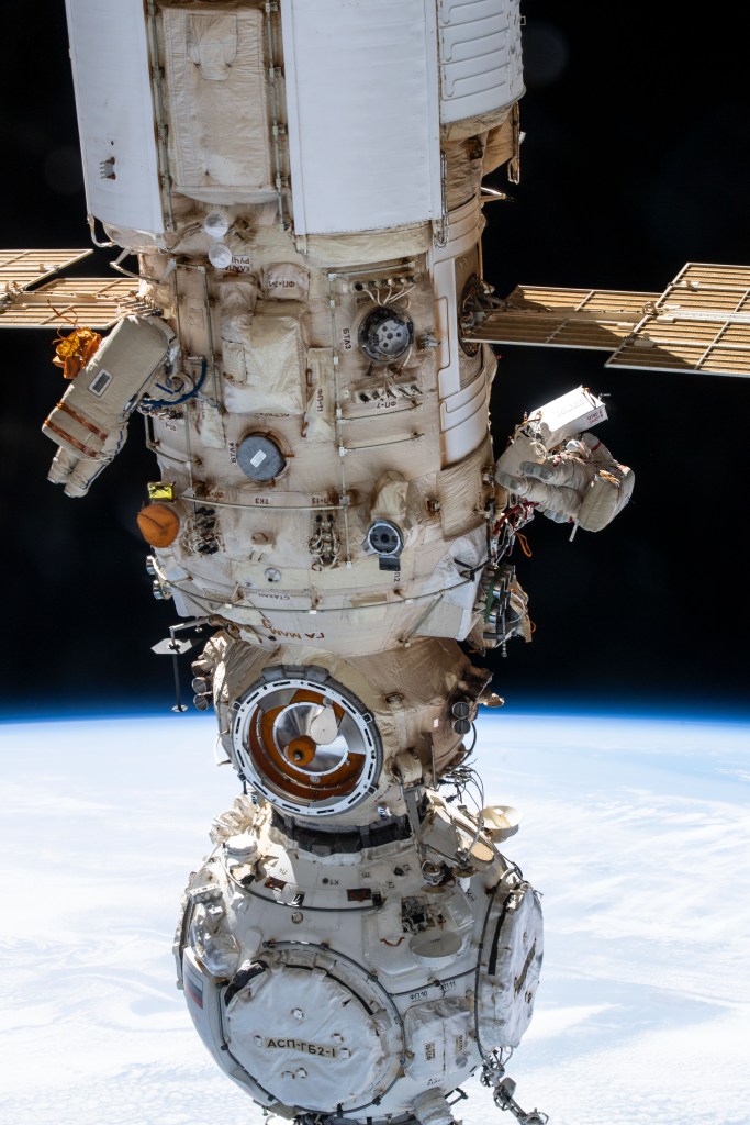 Two spacewalkers from Roscosmos are pictured on either side of the Nauka multipurpose laboratory module as the Intermtional Space Station orbited 260 miles above the Atlantic Ocean off the coast of Conakry, the capitol of Guinea. Cosmonauts (from left) Denis Matveev and Oleg Artemyev worked outside the station's Russian segment for six hours and 37 minutes outfitting Nauka and configuring the European robotic arm.