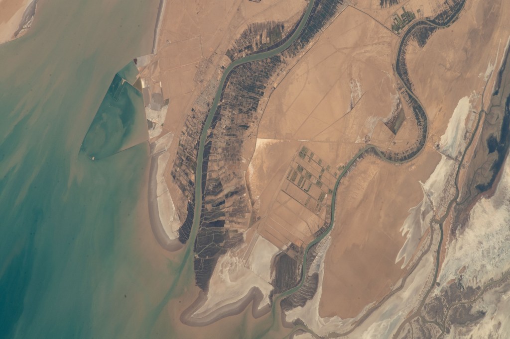 The Arvand Roud (center) is a river that separates the southern borders of Iraq and Iran on the Persian Gulf coast. At right, is the Bahmanshir River in Iran that drains into the Persian Gulf. The International Space Station was orbiting 262 miles above Saudi Arabia near the island nation of Bahrain at the time this photograph was taken.